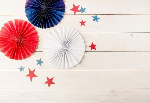 Decorations for 4th July, Independence Day USA. Paper fans and stars on white wooden background. Copy space, flat lay