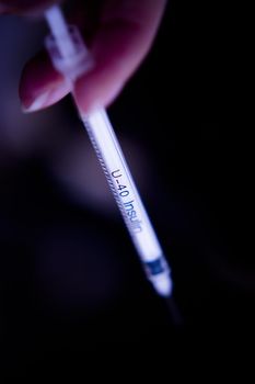 Insulin injecting syringe held by nurses hand. Copy space