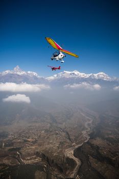 Ultralight trike and plane fly over Pokhara and Annapurna region. Machapuchare or fishtail and Himalayas on the background. Tourism in Nepal