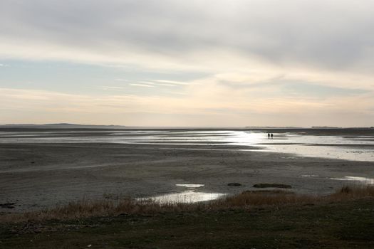 Two people walking a sandbank between Terschelling and Vlieland in The Netherlands