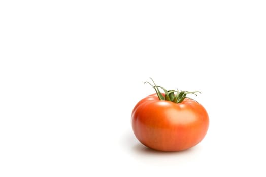 One realistic looking fresh red tomato isolated in a white background side view