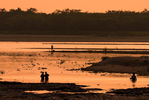 Asian Women fishing in the river. silhouette at sunset. Village life in Asia