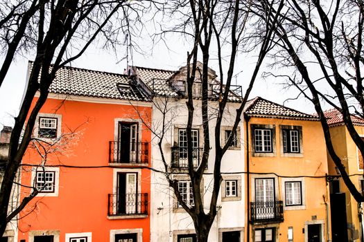 Old colorful and beautiful facades with vintage streetlight in Lisbon streets in Spring. Clothesline in the facade with hanging clothes