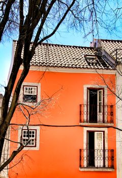 Old colorful and beautiful facades with vintage streetlight in Lisbon streets in Spring. Clothesline in the facade with hanging clothes