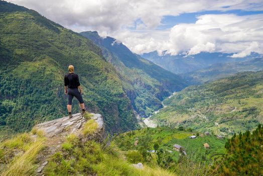 Man standing on top of the hill in Himalayas. Achievement and success. Trekking in Nepal