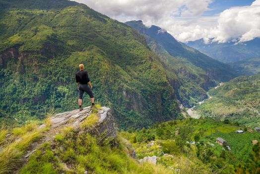 Man standing on top of the hill in Himalayas. Achievement and success. Trekking in Nepal