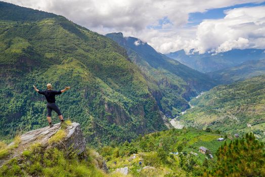 Man standing on top of the hill in Himalayas. Achievement and success. Trekking in Nepal