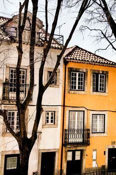 Old colorful and beautiful facades with vintage streetlight in Lisbon streets in Spring. Clothesline in the facade with hanging clothes