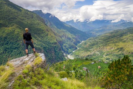 Man standing on top of the hill in Himalayas. Achievement and success. Trekking in Nepal