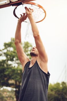 Basketball player installing the net on the basketball hoop.