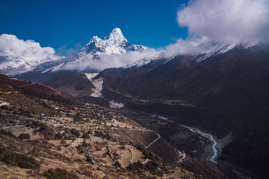 Ama Dablam summit or peak and Nepalese village in Himalayas. Travel trekking and tourism in Nepal