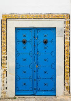 Blue aged door with ornament and tiles from Sidi Bou Said in Tunisia