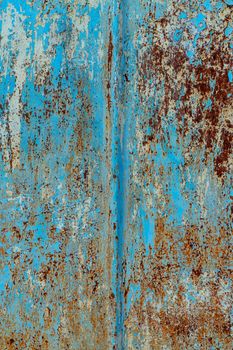 rust and damaged blue and yellow paint on metal sheet. Backgrounds and textures