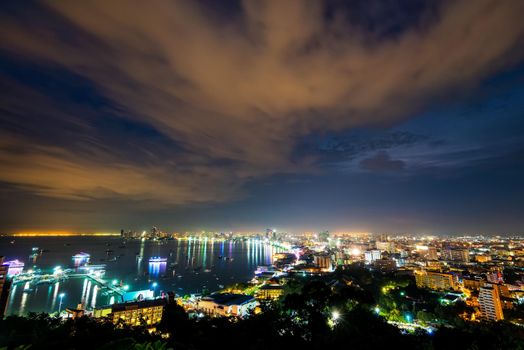 High view on viewpoint see cityscape with colorful light at the beach and the sea of Pattaya Bay, beautiful landscape of Pattaya City at night scene landmark in Chonburi, Travel Asia to Thailand