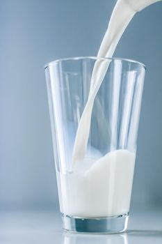 Dairy, healthy nutrition and breakfast concept - World Milk Day, pouring into glass on marble table