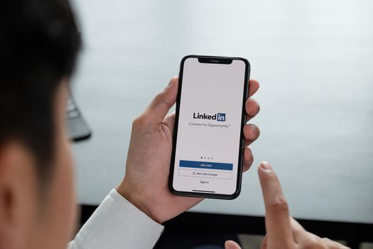 CHIANG MAI, THAILAND, APR 06, 2019 : A man holds Apple iPhone Xs with LinkedIn application on the screen.LinkedIn is a photo-sharing app for smartphones.