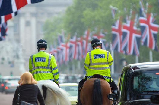 LONDON, UK - CIRCA APRIl 2011: Two mounted police officers on the Mall, Buckingham Palace in the background.