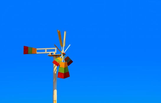 The windmills stand still against the sky on a clear day.