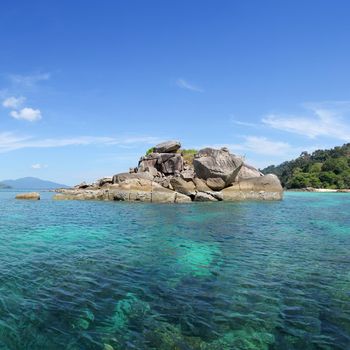 The island has a rocky beach. In areas with snorkel coral.