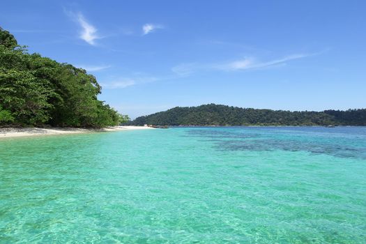 The coastal water green with sky blue coral islands.