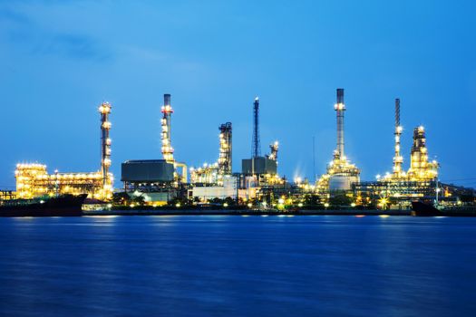 Oil refinery industry with tube and oil tank along twilight sky