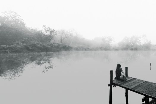 Young women sitting on a wooden bridge. Black and white picture