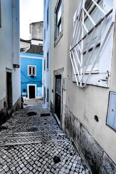 Narrow and colorful streets with majestic facades, windows and balconies of Lisbon city in Portugal in a cloudy day