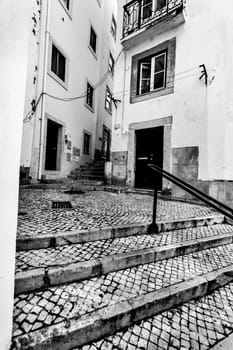 Narrow and colorful streets with majestic facades, windows and balconies of Lisbon city in Portugal in a cloudy day