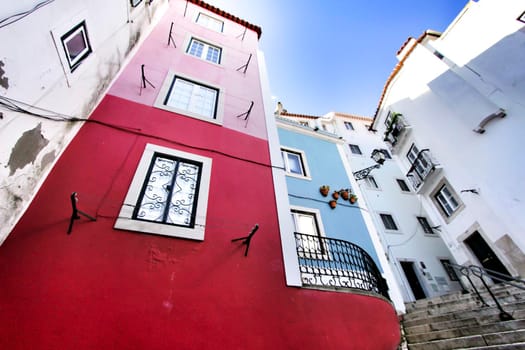 Narrow and colorful streets with majestic facades, windows and balconies of Lisbon city in Portugal in a cloudy day