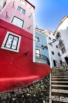 Narrow and colorful streets with majestic facades, windows and balconies of Lisbon city in Portugal in a cloudy day