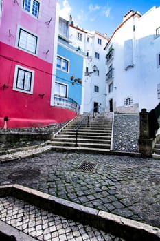 Narrow and colorful streets with majestic facades, windows and balconies of Lisbon city in Portugal in a cloudy day