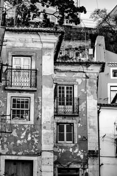 Old damaged facades with vintage streetlight in Lisbon streets in Spring.