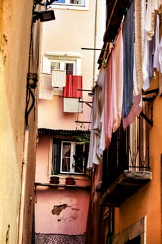 Narrow and colorful streets with majestic facades, windows and balconies of Lisbon city in Portugal in a cloudy day