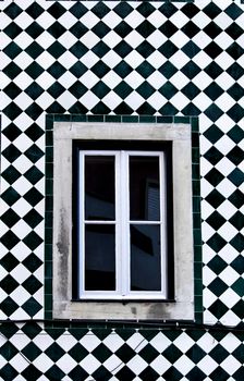 Old colorful and bright typical facade in Lisbon with beautiful vintage wooden window