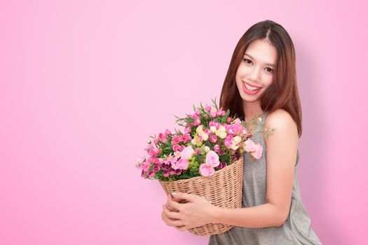 Girl holding a basket of flowers.  Isolated on white.