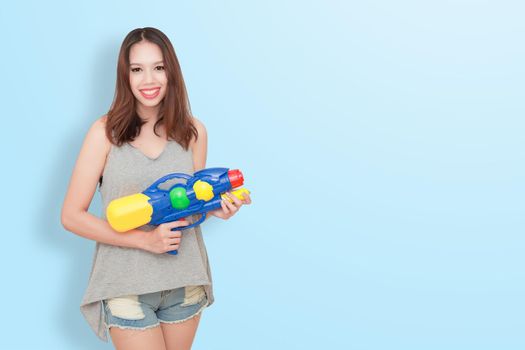 Girl holding a water gun and happy playing (for Songkran festival  day in Thailand).
