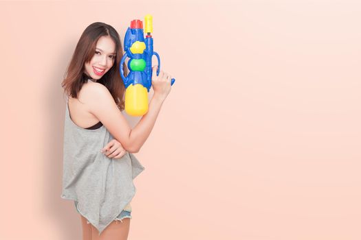 Girl holding a water gun and happy playing (for Songkran festival  day in Thailand).