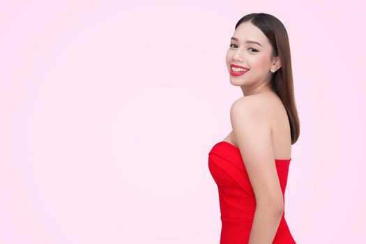 Beautiful sexy young woman in a red dress on a pink background
