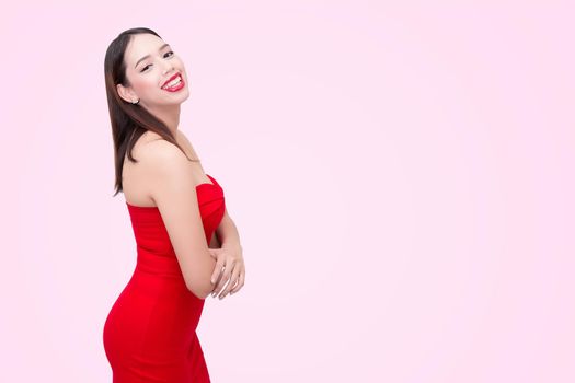 Beautiful sexy young woman in a red dress on a pink background