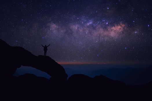Man who feels on top of the world looking at the milky way