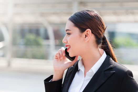 Attractive businesswoman talking on mobile phone with client.