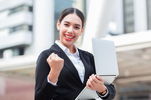 Business success - Celebrating businesswoman overlooking the city center