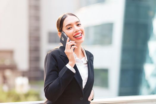 Attractive businesswoman talking on mobile phone with client.