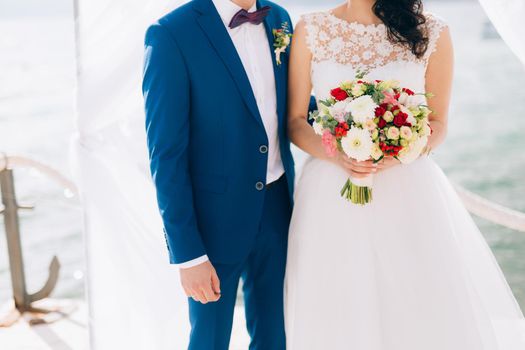 Wedding bridal bouquet of roses, chrysanthemums, Eucalyptus Baby Blue in the hands of the bride. Wedding in Montenegro, Adriatic.