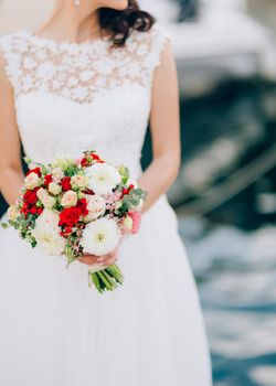 Wedding bridal bouquet of roses, chrysanthemums, Eucalyptus Baby Blue in the hands of the bride. Wedding in Montenegro, Adriatic.