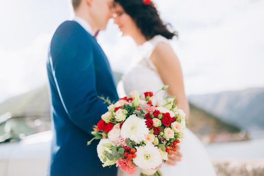 Wedding bridal bouquet of roses, chrysanthemums, Eucalyptus Baby Blue in the hands of the bride. Wedding in Montenegro, Adriatic.