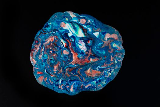 Acrylic blue and red paint with glitters is poured on a black background. An abstract painting with a multi-colored surface. Search for a palette for creativity.