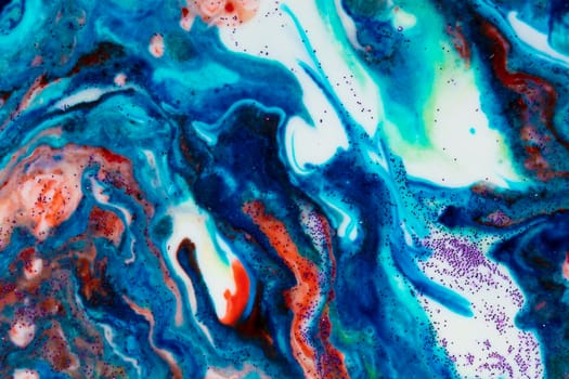 The background is acrylic blue with red lines and sparkles. Colorful marble texture. Fluid liquid marble. Art picture. Avant-garde creativity.