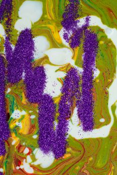 A vertical background of many textures, shapes and materials. Purple sparkles are scattered on a multicolored acrylic background.