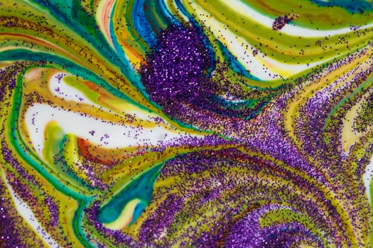 Multicolored acrylic backdrop sprinkled with purple sparkles. Contemporary creativity. Colorful avant-garde rich texture. A background made up of many shapes and materials.